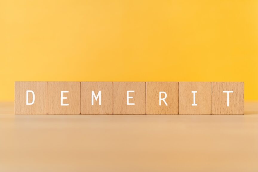 「DEMERIT」と書かれた積み木